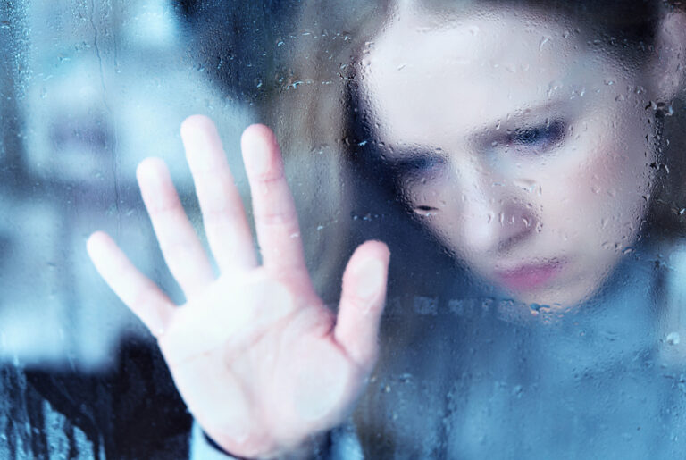 hand of girl melancholy and sad at the window in the rain