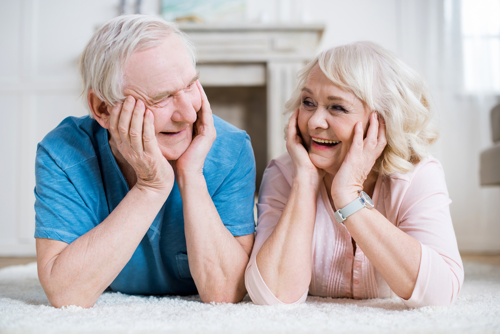 This image shows two old age couple happily looking at each other